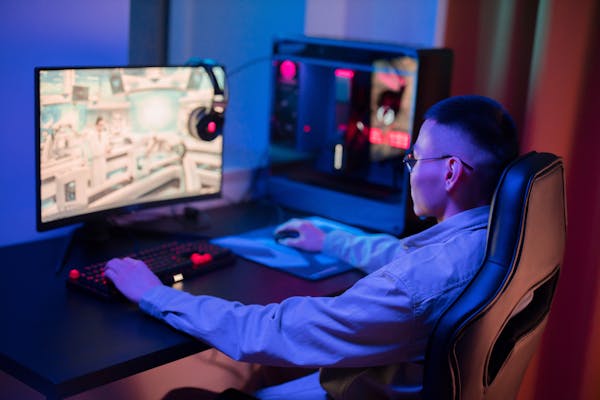 Gamer at PC with headphones in gaming setup