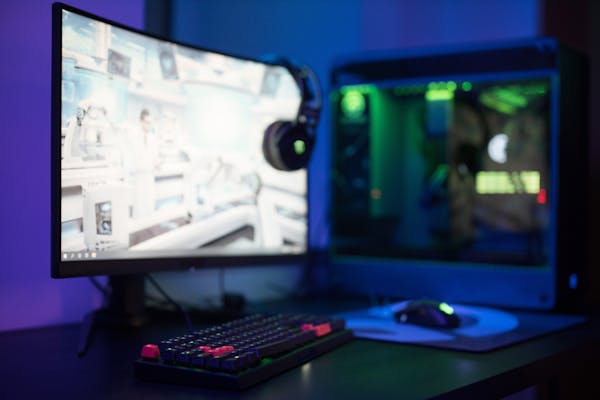 PC gaming setup with curved monitor and RGB keyboard